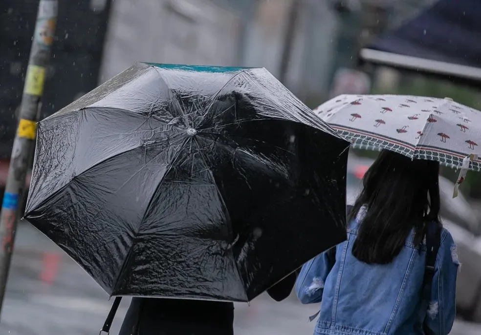 Pedestres enfrentam chuva — Foto: BRUNO ROCHA/ENQUADRAR/ESTADÃO CONTEÚDO